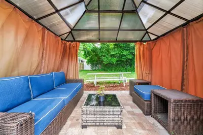 a patio with a blue couch and a table at Cozy 2bd 2bth House Walk to Local Gems in Orlando