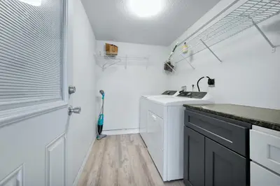a white kitchen with a sink and a shower at Cozy 2bd 2bth House Walk to Local Gems in Orlando