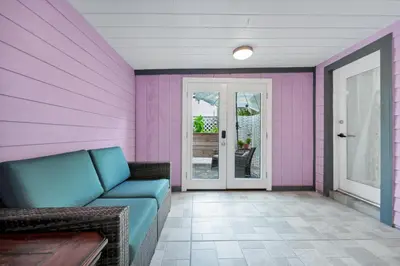 a living room with a couch and a pink wall at Cozy 2bd 2bth House Walk to Local Gems in Orlando