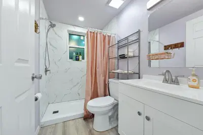 a white bathroom with a sink toilet and a shower at Cozy 2bd 2bth House Walk to Local Gems in Orlando