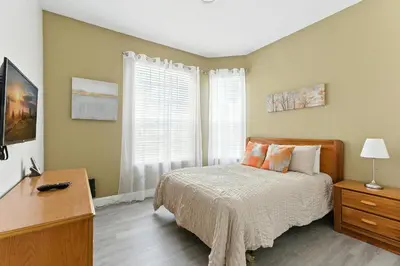 a bedroom with a bed and a desk and a window at 3BR Resort Condo Pool Balcony Near Disney in Kissimmee