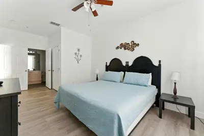 a bedroom with a bed and a ceiling fan at 3BR Resort Condo Pool Balcony Near Disney in Kissimmee