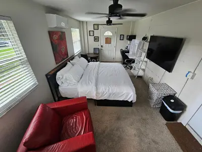 a bedroom with a bed and a couch and a tv at Sanford Suite King Bed Work-Ready Near Beach MCO in Sanford