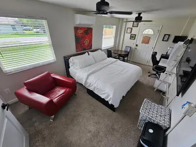 a bedroom with a bed and a red chair at Sanford Suite King Bed Work-Ready Near Beach MCO in Sanford
