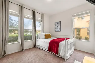 a white bedroom with windows and a bed with a red blanket at 4 Bedrooms 5 Bathrooms Bella Vida 871Mb in Kissimmee