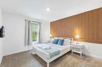 a bedroom with a bed with blue pillows and a window at 8740 Enchanted Stay near Disney in Kissimmee