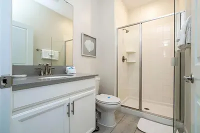 a bathroom with a sink and a toilet and a shower at Refúgio 4Q com Piscina em Storey Lake in Kissimmee