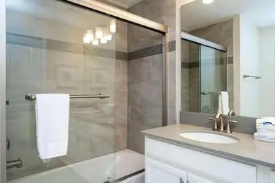a bathroom with a shower with a sink and a mirror at Refúgio 4Q com Piscina em Storey Lake in Kissimmee