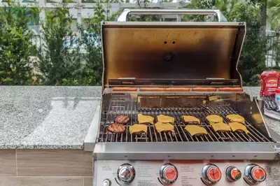 a grill with hamburgers and food cooking on it at Aqua Azul Oasis in Kissimmee-minutes from Disney in Kissimmee