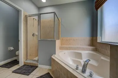 a bathroom with a tub and a shower and a sink at Terra Verde Lakeview Escape in Kissimmee