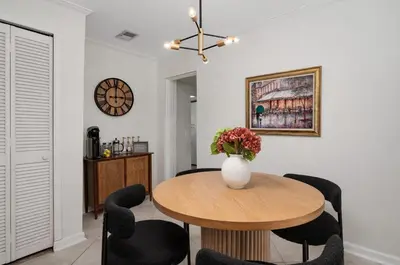 a dining room with a table and chairs and a vase with flowers at Winter Park Gem 2BR Near Parks 3MI to Downtown in Orlando