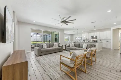 a living room with a couch and chairs and a kitchen at 2605 Yountville Ave in Kissimmee