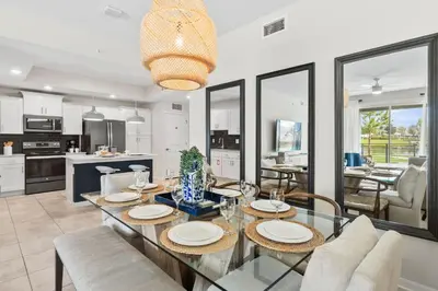 a kitchen and dining room with a glass table and chairs at 3141 Paradox Circle 101 in Kissimmee
