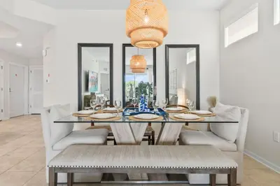 a dining room with a glass table and chairs at 3141 Paradox Circle 101 in Kissimmee