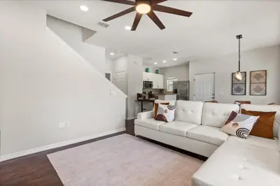 a living room with a white couch and a ceiling fan at 4 Bedrooms 3 Bathrooms Lucaya Village 23-108 in Kissimmee
