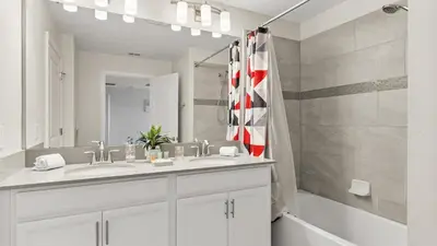 a white bathroom with a sink and a shower at Summer in Style - 4 BR TownHome with Private pool in Kissimmee