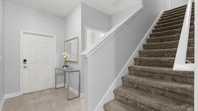 a staircase in a home with white walls and a white door at Summer in Style - 4 BR TownHome with Private pool in Kissimmee