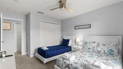 a bedroom with a bed and a blue bedspread at Summer in Style - 4 BR TownHome with Private pool in Kissimmee