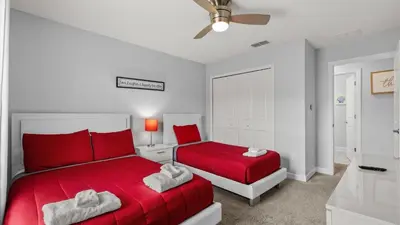 a bedroom with two beds and a red bedspread at Summer in Style - 4 BR TownHome with Private pool in Kissimmee