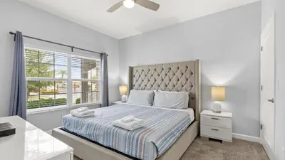 a bedroom with a large bed and a window at Summer in Style - 4 BR TownHome with Private pool in Kissimmee