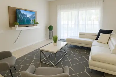 a living room with a couch and a table at 4BRRenovateNO Resort feePrivate PoolDisney in Kissimmee