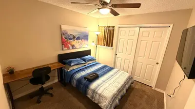 a bedroom with a bed and a desk and a ceiling fan at J10 Private Room with Smart TV Near Everything in Orlando