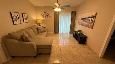 a living room with a couch and a ceiling fan at L12 Private Room with Smart TV Near Everything in Orlando