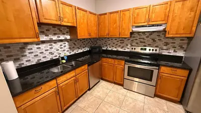 a kitchen with wooden cabinets and a stove top oven at L12 Private Room with Smart TV Near Everything in Orlando