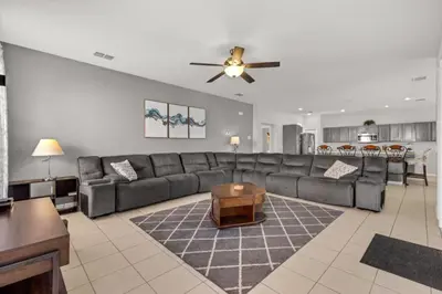 a living room with a couch and a ceiling fan at 6 Bedrooms - 5,5 Bathrooms - Bella Vida 4529Ss in Kissimmee