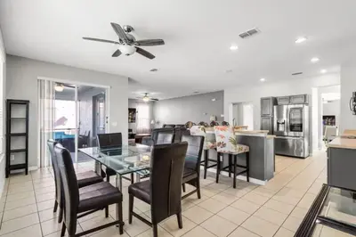 a kitchen and dining room with a glass table and chairs at 6 Bedrooms - 5,5 Bathrooms - Bella Vida 4529Ss in Kissimmee