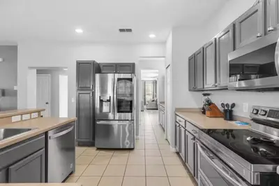 a large kitchen with stainless steel appliances and cabinets at 6 Bedrooms - 5,5 Bathrooms - Bella Vida 4529Ss in Kissimmee