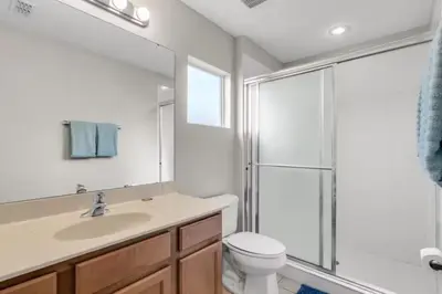 a bathroom with a toilet and a sink and a shower at 6 Bedrooms - 5,5 Bathrooms - Bella Vida 4529Ss in Kissimmee