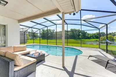 a patio with a swimming pool with a glass roof at 6 Mi to Disney World Lake-View Retreat with Pool! in Kissimmee