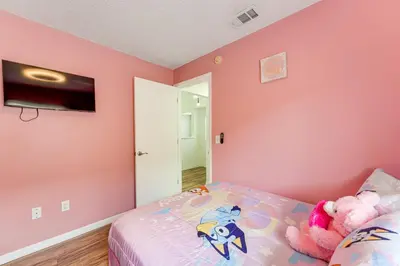 a bedroom with pink walls and a bed with a stuffed animal at 6 Mi to Disney World Lake-View Retreat with Pool! in Kissimmee