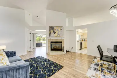 a living room with a blue couch and a fireplace at 6 Mi to Disney World Lake-View Retreat with Pool! in Kissimmee