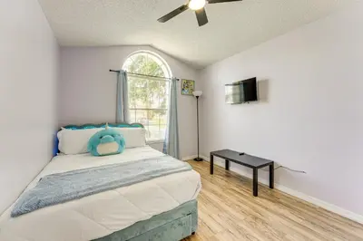 a bedroom with a bed with a table and a window at 6 Mi to Disney World Lake-View Retreat with Pool! in Kissimmee