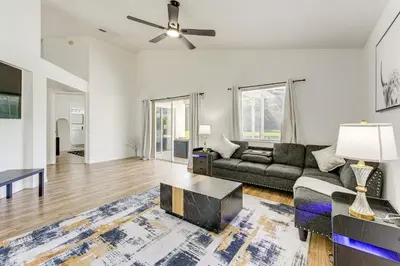 a living room with a couch and a table at 6 Mi to Disney World Lake-View Retreat with Pool! in Kissimmee