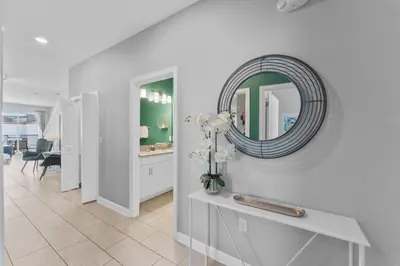 a hallway with a mirror and a table with flowers at 4824 Resort Pool House Disney Universal Orlando in Kissimmee