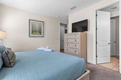 a bedroom with a bed and a dresser with a television at 361 Pendant ct in Orlando