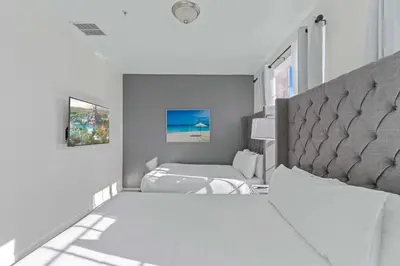 a white bedroom with two beds and a window at 8036 Spacious Fresh 3BR3.5BA at Vista Cay 133 in Orlando