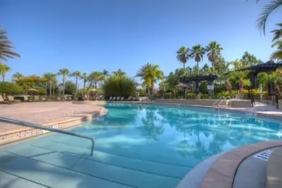 a large swimming pool with palm trees in a resort at 3-Story sanctuary Condo in the heart of Orlando85 in Orlando