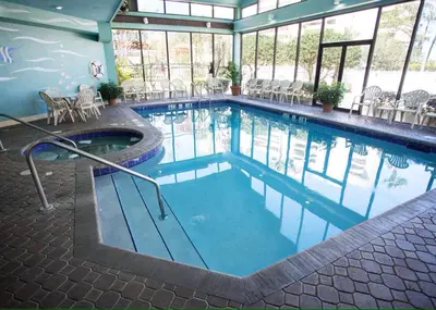 a large swimming pool with chairs and tables in a building at 2701 Enclave Condo near Univesal-Lakeview in Orlando