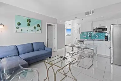 a living room with a blue couch and a kitchen at 2701 Enclave Condo near Univesal-Lakeview in Orlando