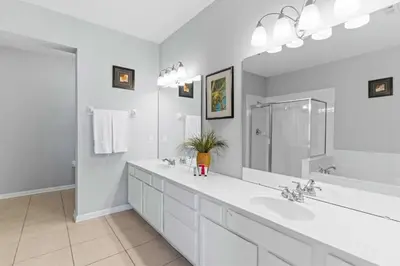 a white bathroom with two sinks and a large mirror at 4840 A Hidden Gem in the Heart of Orlando – 303 in Orlando