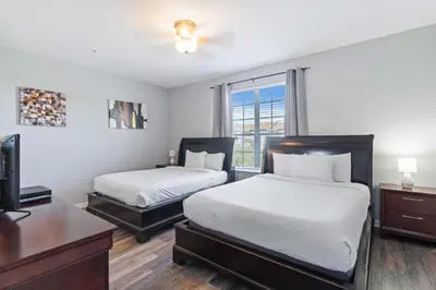 a bedroom with two beds and a desk and a tv at 4840 A Hidden Gem in the Heart of Orlando – 303 in Orlando