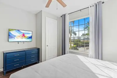 a bedroom with a bed and a tv and a window at 5049 Ultimate Orlando retreat at Vista Cay 203 in Orlando