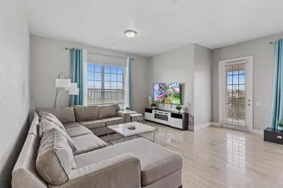 a living room with a couch and a tv at 5048 Light and Airy Resort 4BD Apartment 407 in Orlando