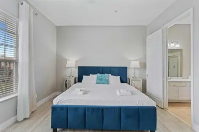 a large blue bed in a white room with a mirror at 5048 Light and Airy Resort 4BD Apartment 407 in Orlando