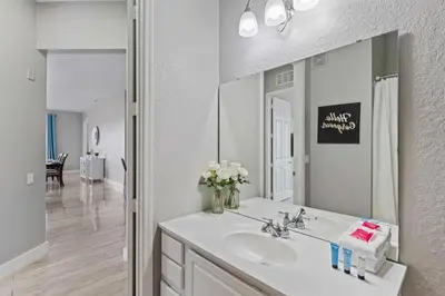 a white bathroom with a sink and a mirror at 5048 Light and Airy Resort 4BD Apartment 407 in Orlando