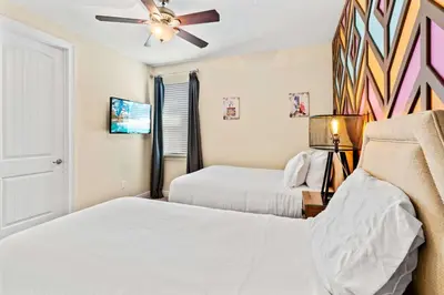 a bedroom with two beds and a ceiling fan at 500 Luxurious 8BR Villa with Private PoolSpa in Orlando